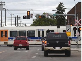 Traffic waits for an LRT train at 105th Street downtown on the new Metro Line in Edmonton on Friday, Aug. 21.