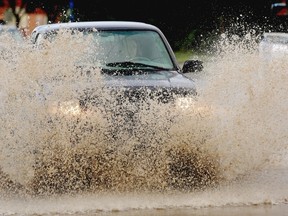 A truck splashes through 104th Street during a sudden afternoon thunderstorm in Edmonton on July 23, 2015.