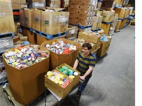 Volunteer Ron Locke moves some of the food collected over a six week period during Christmas at the Edmonton Food Bank on Jan. 8, 2015.