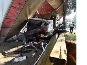 Whyte Ave. apartment resident Shurlon Trotman looks on as police investigate a vehicle rollover July 8. A female passenger died at the scene and the male driver died Thursday.