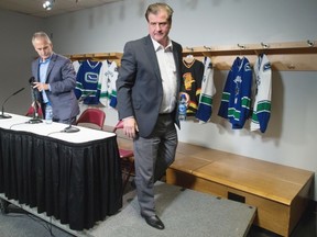 General manager Jim Benning, right, and head coach Willie Desjardins leave the podium after Thursday’s Canucks news conference in Vancouver. The upbeat team insists it’s much better and tougher than most people think.