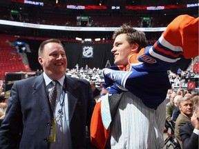 MONTREAL, QC - JUNE 27: Anton Lander of the Edmonton Oilers puts on a team jersey  handed to him from Stu MacGregor after being drafted in the second round of the 2009 NHL Entry Draft at the Bell Centre on June 27, 2009 in Montreal, Quebec, Canada.