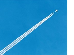 An airplane flies across the blue sky over Edmonton on Aug. 25, 2015.