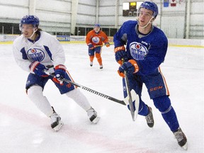 Edmonton Oilers Anton Lander, left, and Connor McDavid run a drill during training camp in Leduc, Alta., on Friday, Sept. 18, 2015.