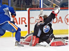 Canadian Olympic women’s team goalie Shannon Szabados makes a save on Nail Yakupov during an Edmonton Oilers practice at Rexall Place on March 5, 2014.