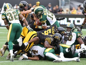 Edmonton Eskimos quarterback Mike Reilly (13) carries the ball during the first half of CFL football action in Hamilton, Ont. against the Hamilton Tiger-Cats on Sept. 19, 2015.