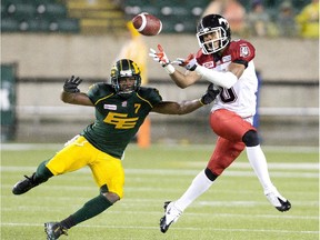 Calgary Stampeders Ciante Evans (0) and Edmonton Eskimos Kenny Stafford (7) try to make the catch during first half action in Edmonton, Alta., on Saturday September 12, 2015.