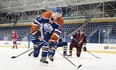 Edmonton Oilers rookie Connor McDavid shoots a puck over a photographer during the NHLPA rookie showcase in Toronto on Sept. 1, 2015.