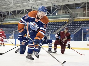 Edmonton Oilers rookie Connor McDavid shoots a puck over a photographer during the NHLPA rookie showcase in Toronto on Sept. 1, 2015.