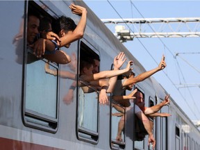 Refugees wave from a train heading to Zagreb at a railway station, near the official border crossing between Croatia and Serbia, near the eastern-Croatian town of Tovarnik, on Sept. 18 2015.