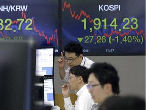 Currency traders watch monitors at the foreign exchange dealing room of the KEB Hana Bank headquarters in Seoul, South Korea, Tuesday, Sept. 1, 2015.