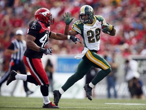 Edmonton Eskimos' Joe Burnett, right, out runs Calgary Stampeders' Deron Mayo, during first CFL football action in Calgary on Sept. 2, 2013.