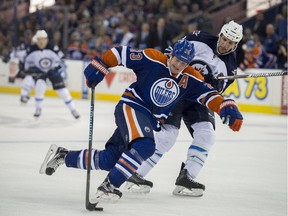 Matt Hendricks, of the Edmonton Oilers, makes his way past Adam Pardy of the Winnipeg Jets in a pre-season game at Rexall Place in Edmonton on Sept. 23, 2015.