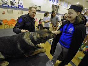 Grade 6 student Maddison Kingham gets a lick from police dog Maverick, 3, who stopped by for a visit with his handler Cst Murray Burke, in 2012.