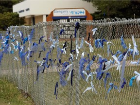 A schoolyard fence at Glengarry School is adorned with 600 blue ribbons, one for each student at the school, in memory of Edmonton Police Service Constable Daniel Woodall.