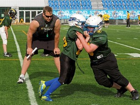 Edmonton Eskimos offensive lineman Matt O'Donnell, shown helping at an amateur football camp at Clarke Field in May 2014, has rejoined the Canadian Football League team after an unsuccessful tryout with the NFL's Cincinnati Bengals.