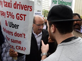 An Uber supporter argues with local taxi drivers during protests outside City Hall in Edmonton on Sept. 16, 2015.