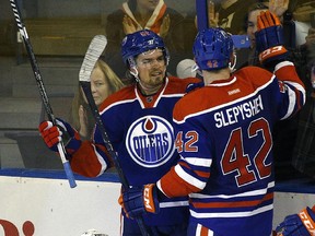 Edmonton Oilers Anton Lander (left) celebrates his second goal of the game against Arizona Coyotes goalie Anders Lindback (front) during second period pre-season NHL action in Edmonton on September 29, 2015. Oilers Anton Slepyshev (right) celebrates with Lander.