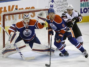 Former Oil Kings teammates Griffin Reinhart (Oilers) and Henrik Sanmuelsson (Coyotes) battle for position in an NHL preseason game last season.