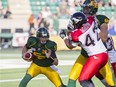 Edmonton Eskimos quarterback Matt Nichols looks for an opening as offensive lineman Matt O'Donnell blocks Deron Mayo of the Calgary Stampeders during a Canadian Football League game at Commonwealth Stadium on Sept. 6, 2014.