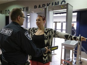 Security guard John Akle waves a metal detector over KaSandra Knox at Rexall Place on Sept. 9, 2015. Metal detectors could be added to City Hall for people wanting to go into council chambers.