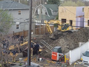 Firefighter work to recover a worker who was killed when a trench collapsed at 108th Avenue and 123rd Street in Edmonton on April 28, 2015.