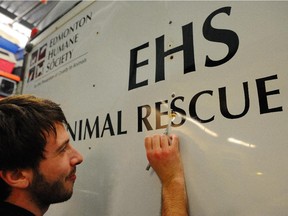 EDMONTON, ALTA: /January/ 25, 2012 --The Edmonton Humane Society (EHS) has a new tool to help with animal rescue missions.  It is an animal rescue trailer to go along with the Society's current animal rescue response vehicle that was used during last summer's Slave Lake fire animal rescue.  The trailer now allows the EHS the proper transport of rescue equipment instead of taking up space in the animal rescue vehicle as in previous missions like the one in Slave Lake last summer (so now there is more space to transport animals).  The trailer was bought with a portion of a $10,000 donation from Hills Pet Nutrition to the EHS' Disaster Fund.  Stefan Candie from Royal Sign and Stamp, who donated new decals, installs them on the trailer in Edmonton, January 25, 2012.