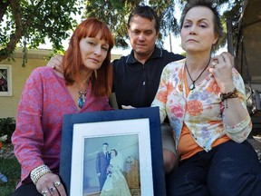 Linda-Rae Carson (left), Todd Walker and Kathie Peterson holding their parents portrait, Sheila and Allen Walker, who were tragically killed in vehicle crash a week earlier. Also is a photo of the family dog named Winston, who was also killed in the accident.