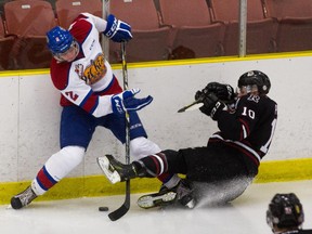 Kyle Yewchuk of the Edmonton Oil Kings bangs the puck away from Evan Polei of the Red Deer Rebels in a Western Hockey League pre-season game on Sept. 5, 2015.
