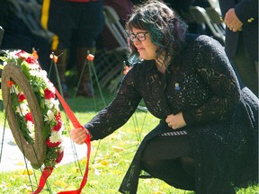 Claire Woodall, the widow of Edmonton Police Service Const. Daniel Woodall, lays a wreath Sunday at the Pillar of Strength, a permanent monument to fallen officers at the Alberta legislature grounds.