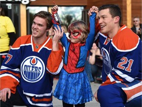Victory for Spider-Mable (Mable Tooke). The six-year-old cancer patient rescued Oilers captain Andrew Ference (R) as part of an elaborate plan by the Children's Wish Foundation. Connor McDavid (L) showed up as a surprise at the Edmonton Valley Zoo. Sept. 28, 2015.