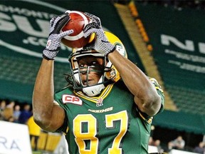 Edmonton Eskimos receiver Derel Walker uses his head to hang on to the ball while being tackled by Hamilton Tiger Cats’ Brandon Stewart during a Canadian Football League game at Commonwealth Stadium on Aug. 21, 2015.