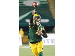 Edmonton Eskimos rookie quarterback James Franklin eludes a tackle by Hamilton Tiger-Cats defensive lineman Ted Laurent during a Canadian Football League game at Commonwealth Stadium on Aug. 21, 2015.