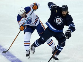 Edmonton Oilers' Tyler Pitlick (15) collides with Winnipeg Jets' Chris Thorburn (22) during first period pre-season NHL hockey action in Winnipeg, Friday, September 25, 2015.