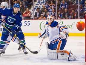 VANCOUVER, BC - APRIL 11: Goalie Ben Scrivens #30 of the Edmonton Oilers watches the puck go in to the corner while Brandon McMillan #21 of the Vancouver Canucks battles with Keith Aulie #22 of the Edmonton Oilers for position in NHL action on April, 11, 2015 at Rogers Arena in Vancouver, British Columbia, Canada.