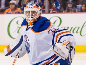 VANCOUVER, BC - APRIL 11: Goalie Ben Scrivens #30 of the Edmonton Oilers watches the puck go in to the corner while Brandon McMillan #21 of the Vancouver Canucks battles with Keith Aulie #22 of the Edmonton Oilers for position in NHL action on April, 11, 2015 at Rogers Arena in Vancouver, British Columbia, Canada.