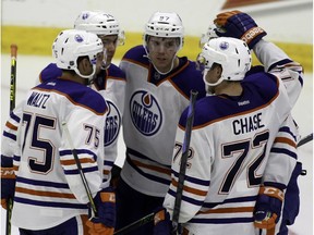 Edmonton Oliers' Connor McDavid (centre) celebrates his first goal of the game against the Vancouver Canucks during third period NHL rookie action in Penticton, B.C. on Friday September 11, 2015.