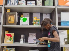Esther Marie Camara, 7, browses the books in the collection. The Stanley A. Milner Library is showing a collection of kids picture books. The IBBY Silent Books Exhibit is doing a tour around the country and They’ll end up on the Italian island of Lampedusa for local and migrant children.