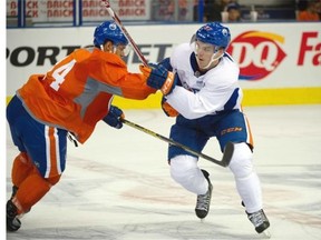 Ethan Bear (l) and Connor McDavid battle at the on-ice session of the 2015 orientation camp for young prospects within the Oilers organization for a six day rookie development camp in Edmonton. July 4, 2015.