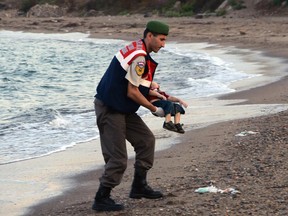 In this Sept. 2, 2015 file photo, a paramilitary police officer carries the lifeless body of three-year-old Alan Kurdi after a number of migrants died and others were reported missing when boats carrying them to the Greek island of Kos capsized near the Turkish resort of Bodrum. The tides also washed up the bodies of Alan's mother Rehan and five-year-old brother Ghalib. The boys' father, Abdullah, survived.