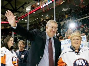 Former New York Islanders coach Al Arbour waves to fans as he leaves the ice with his wife, Claire, after returning to the team to coach his 1,500th NHL game at the Nassau Coliseum in Uniondale, N.Y., on Nov. 3, 2007. Team officials announced Friday that Arbour had passed away at the age of 82.