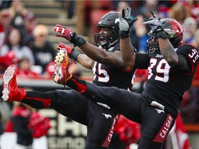 Calgary Stampeders' Freddie Bishop III, left, and Charleston Hughes celebrate their sack of Edmonton Eskimos quarterback James Franklin during first half CFL football action in Calgary on Monday, September 7, 2015.