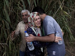 Migrants react upon their arrival on the shores of the Greek island of Lesbos after crossing the Aegean Sea from Turkey on a dinghy on September 9, 2015.