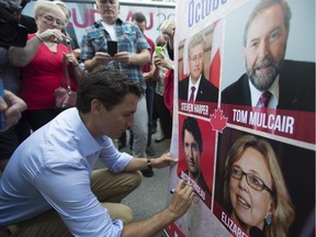 Liberal leader Justin Trudeau signs an election sign earlier this week.