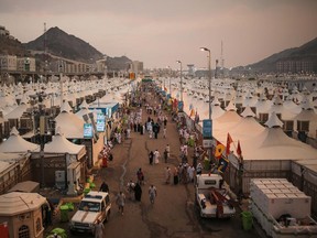 Muslim pilgrims walk past tents, a day after a stampede nearby in which more than 700 people died, in Mina, near the holy city of Mecca. Saudi Arabia faced new accusations of neglect Friday in the hajj disaster that killed over 700 people, the second tragedy at this year's pilgrimage overseen by the kingdom's rulers who base their legitimacy in part on protecting Islam's holiest sites.