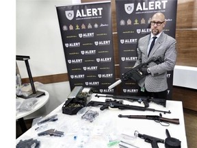 In an August 27 photo supplied by ALERT, ALERT Insp. Darcy Strang hold the KRISS Vector gun seized during a series of August 14 raids on three Edmonton homes.
