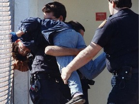 Security guards carry away protester Lianne Laurence from outside Dr. Henry Morgentaler’s private abortion clinic on its first day of operation.