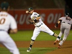 Eric Sogard (28) of the Oakland Athletics completes a double play after tagging out Mac Williamson (51) of the San Francisco Giants during the seventh inning at O.co Coliseum on Sept. 25, 2015 in Oakland, Calif.