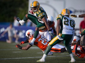Edmonton Eskimos' Skye Dawson (88) leaps over B.C. Lions' Keynan Parker (20) while returning a kick during the first half of a pre-season CFL football game in Vancouver on June 19, 2015.