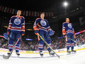 Forwards Taylor Hall, Ryan Nugent-Hopkins and Jordan Eberle of the Edmonton Oilers stand for the singing of the national anthem prior to a game against the Tampa Bay Lightning on Oct. 20, 2014, at Rexall Place in Edmonton